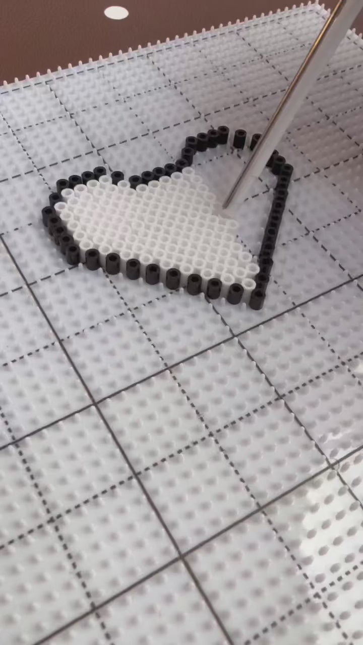 Hands creating Poparooz fuse bead pixel art